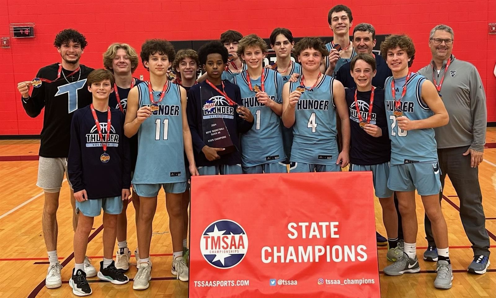 A boys basketball team smiles